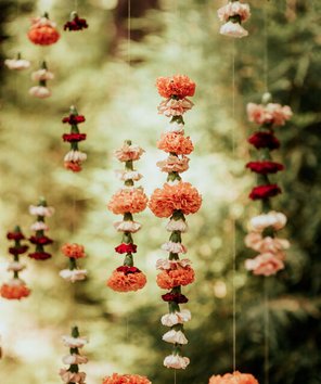 unique hanging flower garlands to look like they are floating behind the mandap for this hindu wedding
