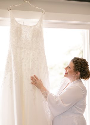 Bride smiling at her wedding dress, excited while getting ready for her ceremony overlooking the vineyards in sonoma, ca