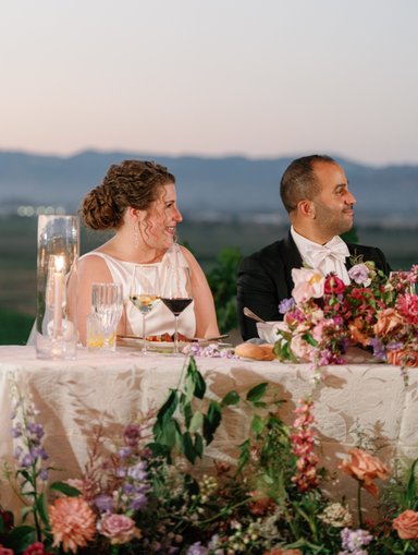 Wedding couple enjoying toasts with View of the vineyards behind them in sonoma wine country for their wedding