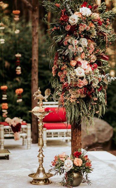 Unique mandap floral design for a wedding in the forest. mandap handmade from redwood trees